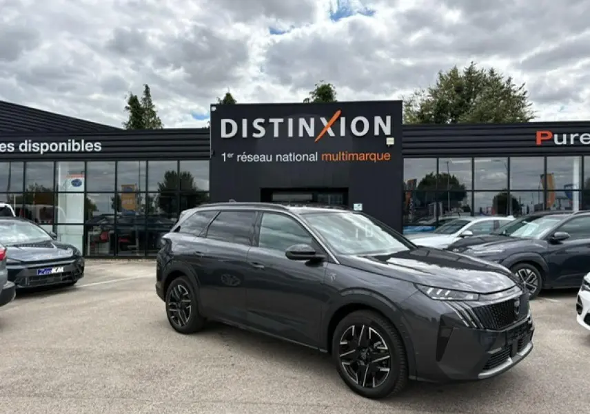 Peugeot 5008 gris titane avec toit noir, vue 3/4 avant droit sur parking devant concession Distinxion.