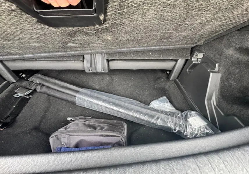 Coffre arrière du Peugeot 5008 gris titane, vue intérieure montrant un rangement sous la banquette arrière.