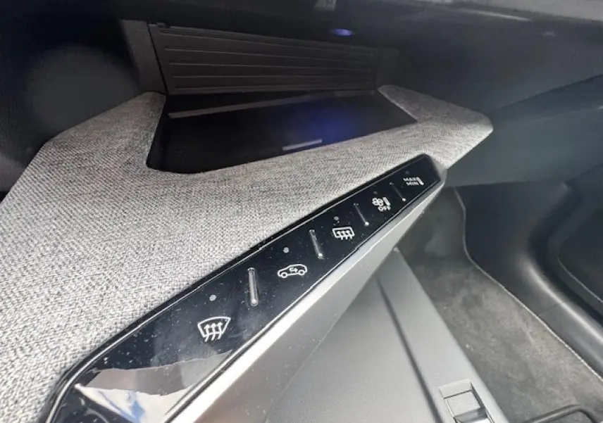 Gros plan sur la console centrale du Peugeot 5008 gris titane, montrant les commandes tactiles de désembuage et circulation d'air.