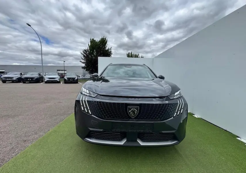 Vue frontale du Peugeot 5008 gris titane avec toit noir, mettant en valeur sa calandre et ses phares LED griffés.