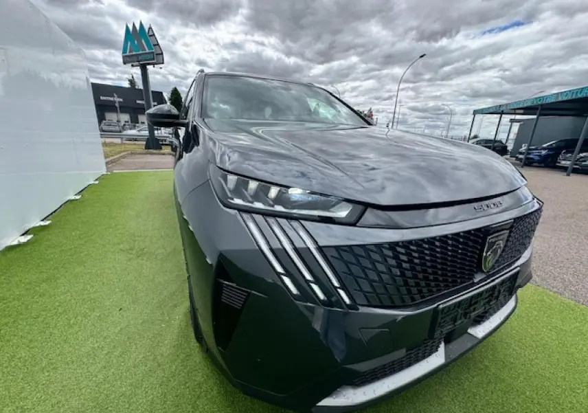 Vue 3/4 avant gauche d'un Peugeot 5008 gris titane avec toit noir et signature lumineuse à LED verticale.