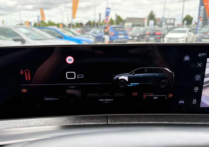 Affichage numérique du tableau de bord Peugeot 5008 hybride, montrant un véhicule gris en profil droit sur écran panoramique.
