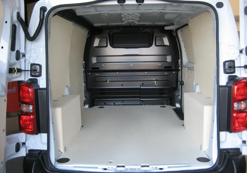 Vue arrière du Peugeot Expert Fourgon blanc 2025 montrant l'espace de chargement vide avec revêtement bois clair.