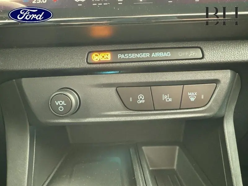 Détail du tableau de bord du Ford Puma 2025 montrant les commandes volume, arrêt auto et dégivrage, avec témoin airbag passager.