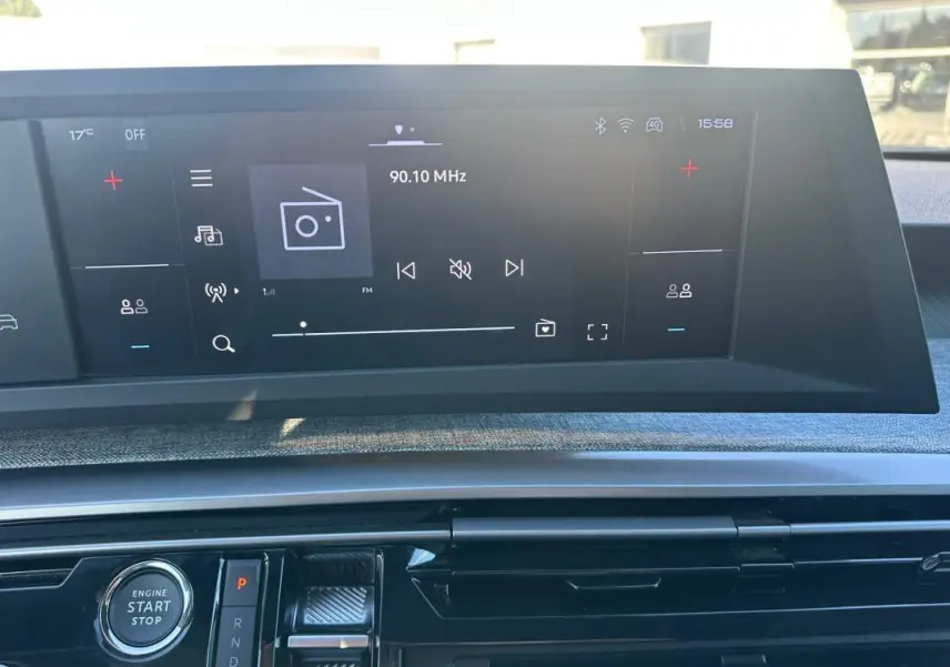 Vue rapprochée du cockpit numérique du Peugeot 3008 Hybrid blanc, affichant l'interface radio et le bouton start/stop.