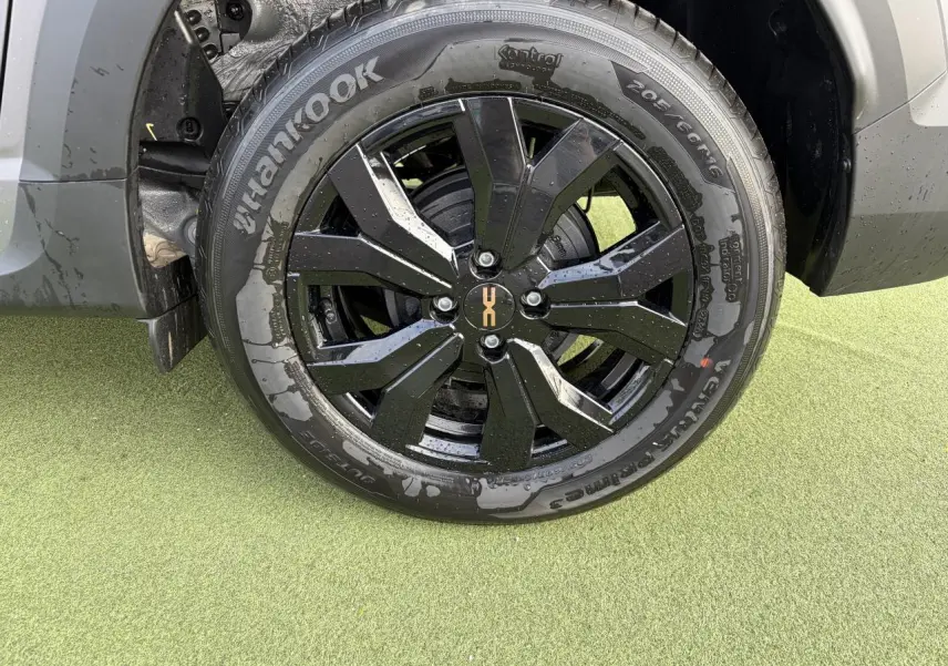 Gros plan sur la roue avant gauche du Dacia Jogger gris schiste métal avec jante aluminium noire 16 pouces Mahalia.