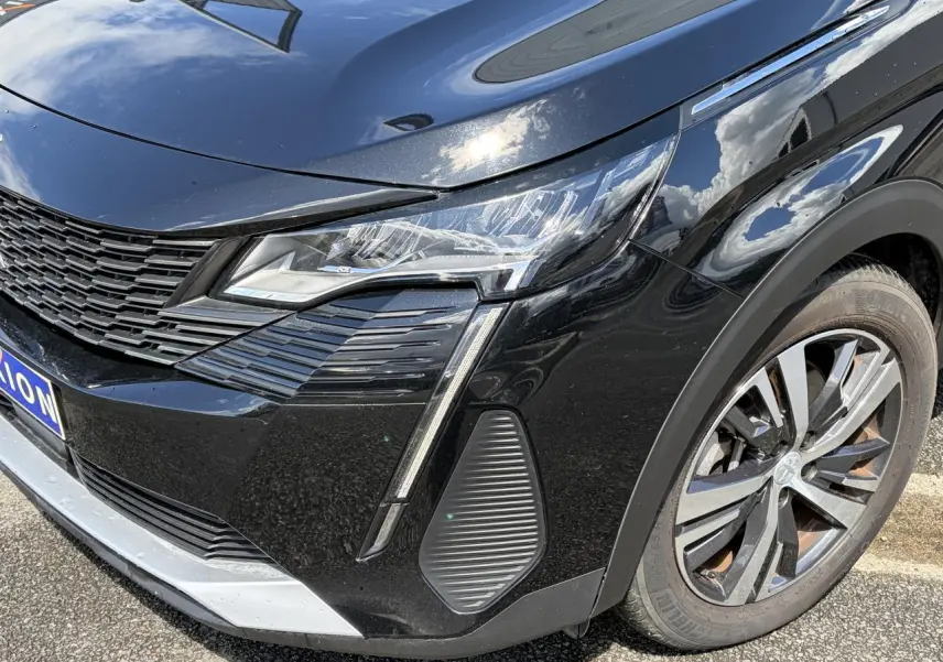 Gros plan sur l'avant droit noir Perla du Peugeot 3008 2024 avec projecteur LED et jante alliage bi-ton.