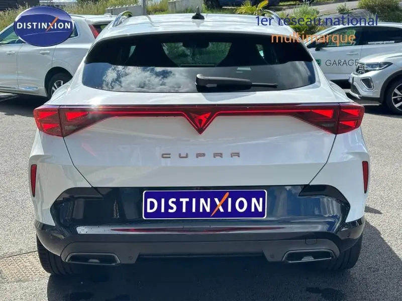 Vue arrière d'un CUPRA Formentor blanc Nevada métallisé avec feux LED reliés et double sortie d'échappement.