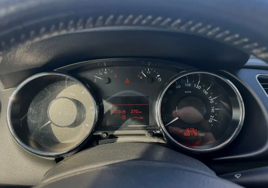 Vue rapprochée du tableau de bord du Peugeot 3008 gris clair 2014, affichant compte-tours, vitesse et jauge carburant.