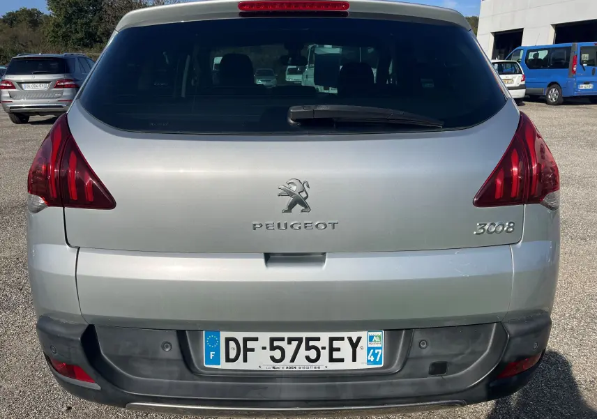 Vue arrière d'un Peugeot 3008 gris clair de 2014 avec feux rouges caractéristiques et plaque d'immatriculation française.