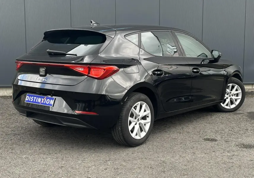 Vue 3/4 arrière droite d'une SEAT Leon 2024 noire Minuit avec vitres arrière surteintées et jantes alliage 16 pouces.