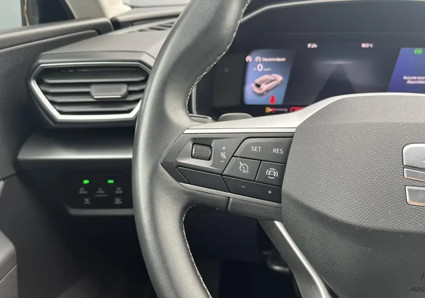Gros plan sur le volant cuir multifonction côté gauche du SEAT LEON 2.0 TDI 150 DSG Style avec tableau de bord digital.