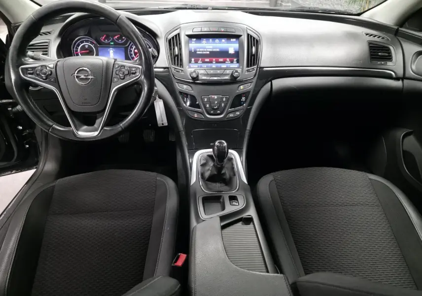 Vue intérieure avant de l'Opel Insignia 1.6 CDTI Cosmo 2016, tableau de bord noir avec volant cuir et écran tactile central.