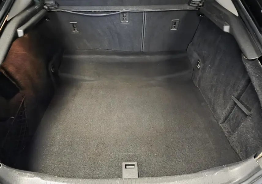 Coffre ouvert vu de face, intérieur noir spacieux et propre de l'Opel Insignia 2016 finition Cosmo.