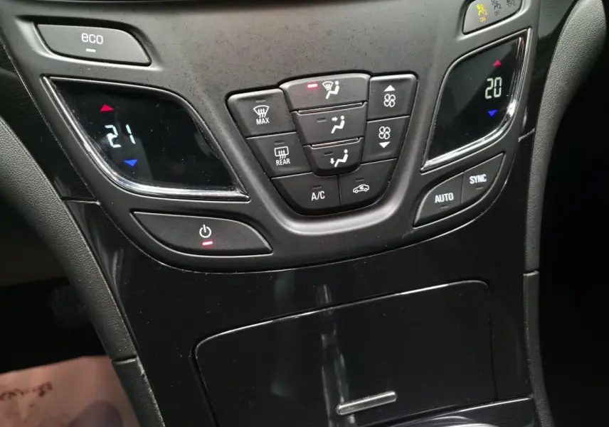 Vue rapprochée de la console centrale noire de l'Opel Insignia 2016 avec commandes climatisation bi-zone et bouton eco.
