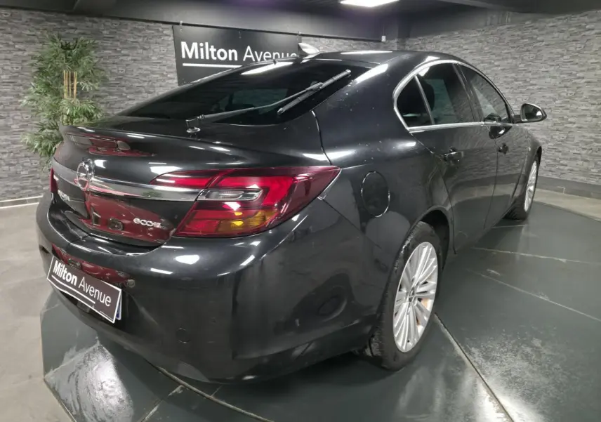 Opel Insignia noire vue 3/4 arrière droit, avec vitres arrière fumées et jantes alliage 18 pouces.