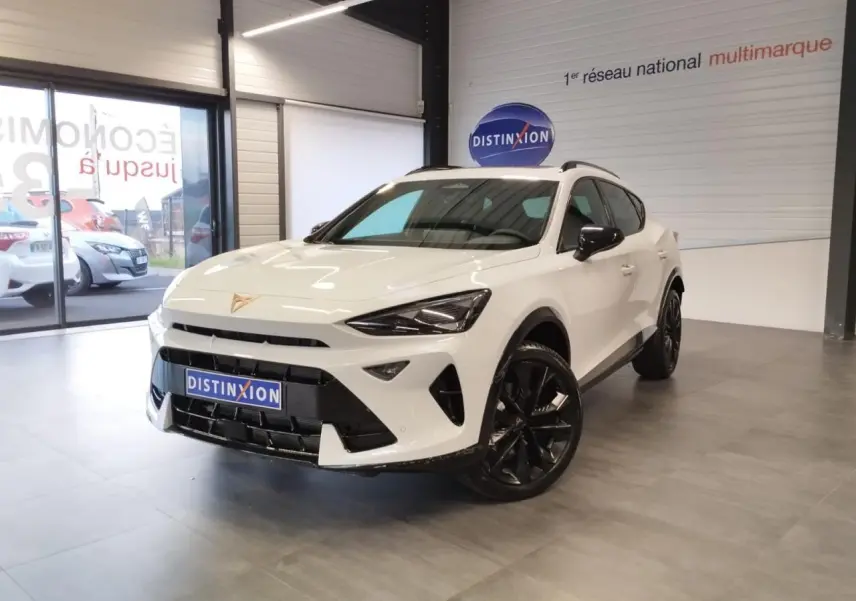 Vue 3/4 avant d'un CUPRA Formentor blanc Nevada avec jantes noires et détails noirs contrastants en intérieur showroom.