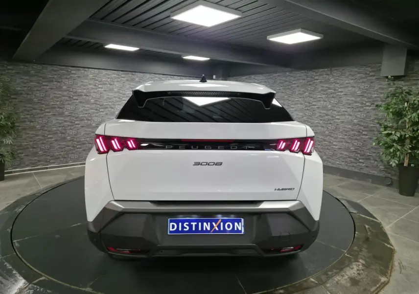 Vue arrière d'un Peugeot 3008 blanc hybride 2025 avec feux arrière LED à trois griffes et bandeau noir laqué.