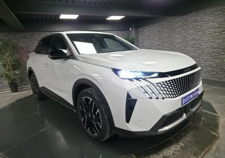 Peugeot 3008 blanc en 3/4 avant droit, avec calandre noire à motif géométrique et phares LED allumés.