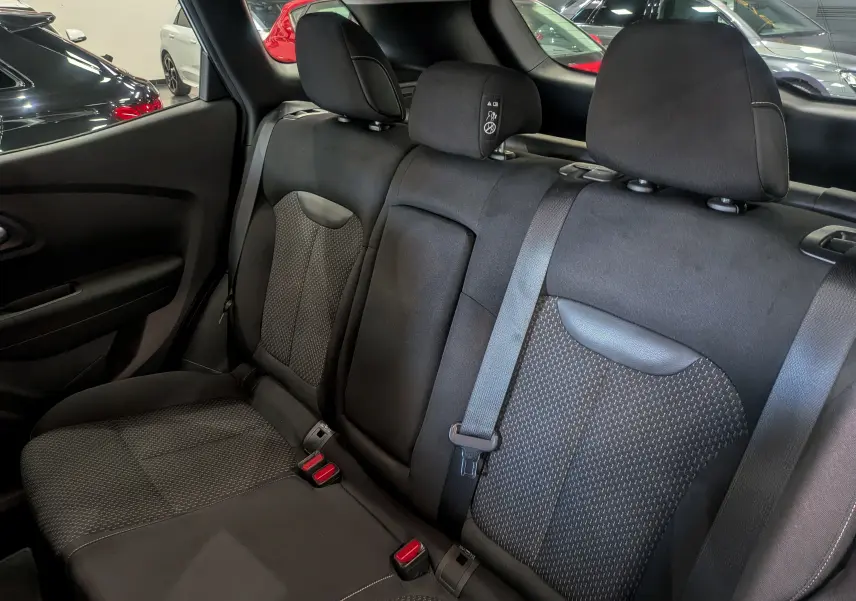 Vue intérieure des sièges arrière en tissu noir du Renault Kadjar 1.5 Blue dCi 115 CH BUSINESS, avec ceintures de sécurité visibles.