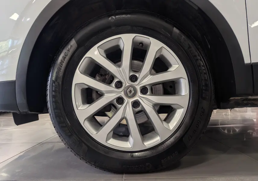 Gros plan sur la roue avant gauche d'un Renault Kadjar blanc glacier, jante alliage argentée et pneu Michelin.