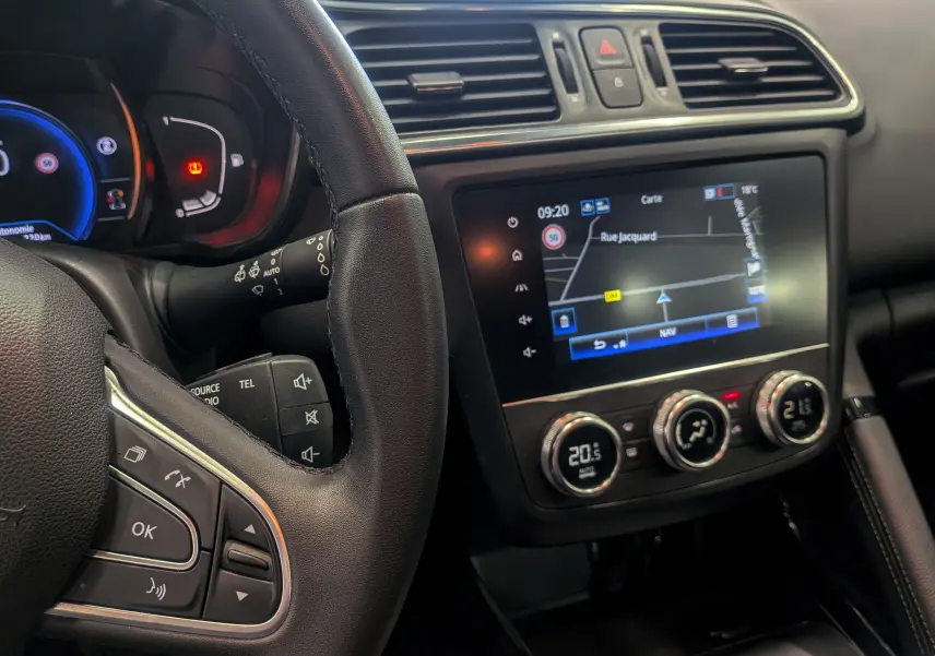 Vue intérieure du tableau de bord du Renault Kadjar 2020, avec volant en cuir et écran tactile de navigation allumé.