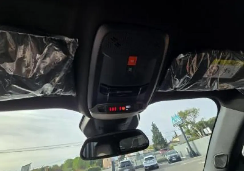 Vue intérieure du plafond avant du Peugeot 2008 blanc avec commandes d'éclairage et rétroviseur central visible