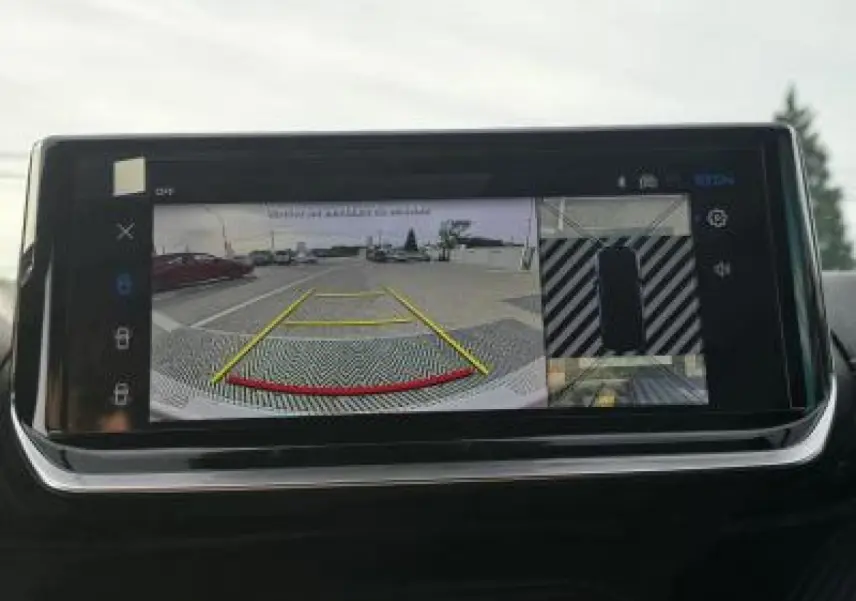 Écran tactile intérieur affichant la caméra 360° de recul du Peugeot 2008 blanc toit noir, vue arrière stationnement.