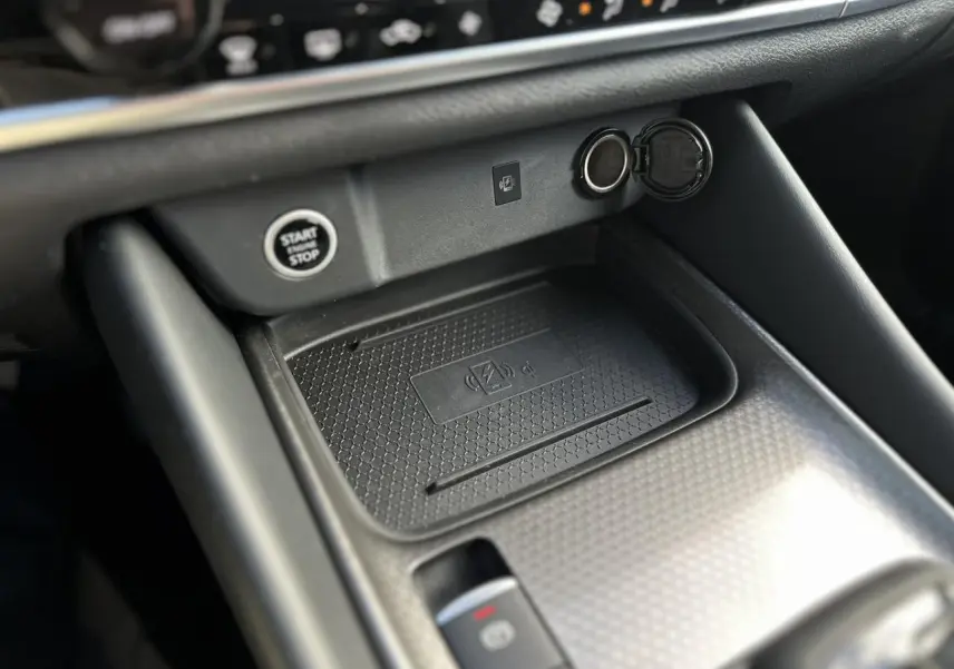 Gros plan sur la console centrale noire du Nissan Qashqai 2025 avec bouton start/stop et chargeur sans fil.