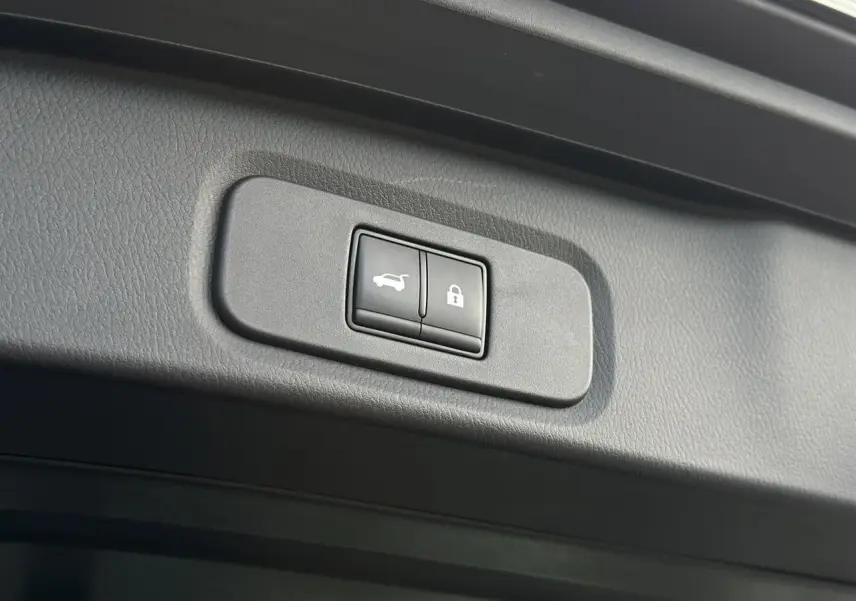 Boutons de hayon électrique et verrouillage intégrés dans le panneau intérieur du coffre du Nissan Qashqai noir nacré 2025.