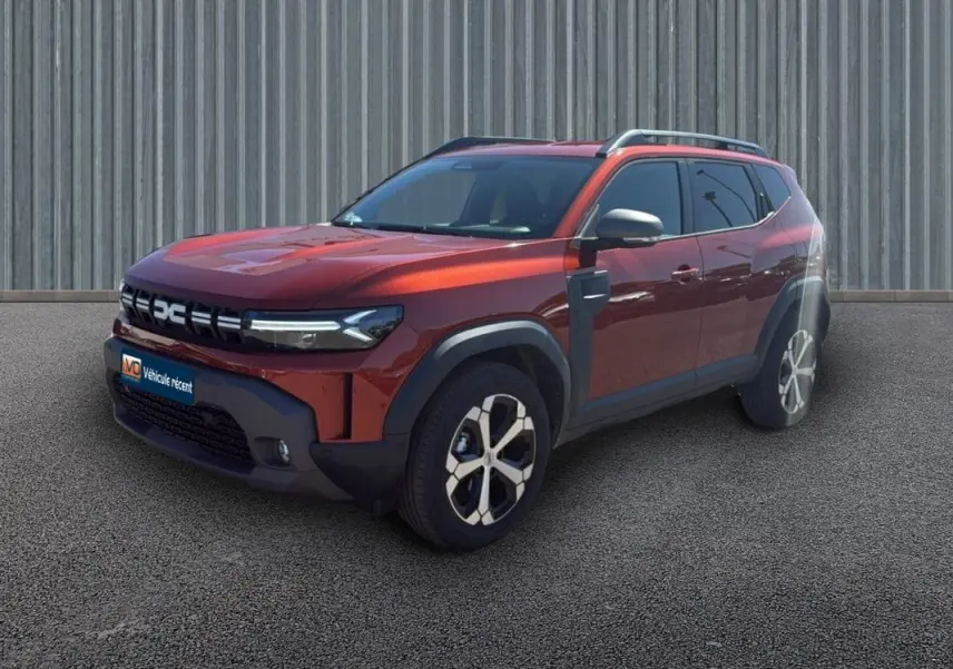Vue 3/4 avant d'un Dacia Duster 2025 orange avec jantes alliage 18 pouces et barres de toit visibles.