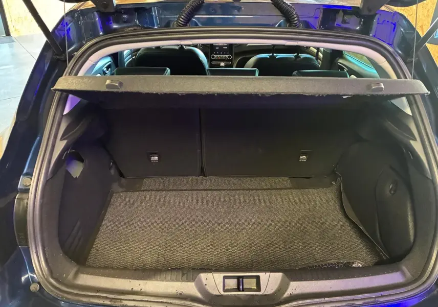 Coffre ouvert vu de l'arrière d'une Renault Mégane 1.5 dCi bleu, montrant l'espace de chargement et l'intérieur noir.