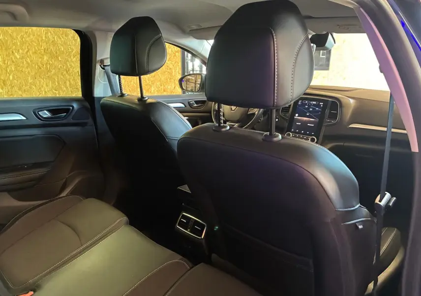 Vue intérieure arrière de la Renault Mégane 1.5 DCI 115 Intens 2021, sièges cuir noir et console centrale avec aérateurs.