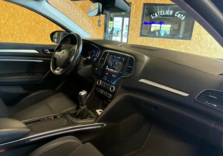 Intérieur avant droit d'une Renault Mégane 1.5 DCI 115 Intens 2021 avec tableau de bord noir et boîte manuelle.