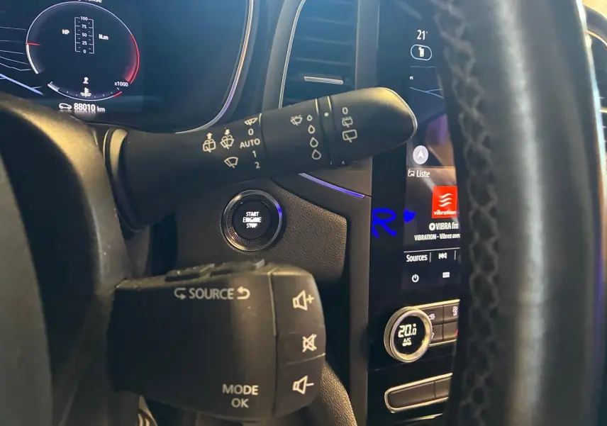 Vue rapprochée de l'intérieur de la Renault Mégane 1.5 DCI 115 Intens 2021, montrant le volant, commandes et tableau de bord numérique.