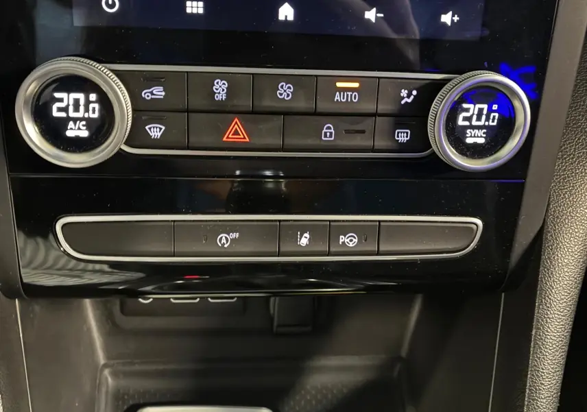 Gros plan sur la console centrale de la Renault Mégane 1.5 DCI 115 Intens 2021, avec commandes climatisation et boutons fonctionnels.