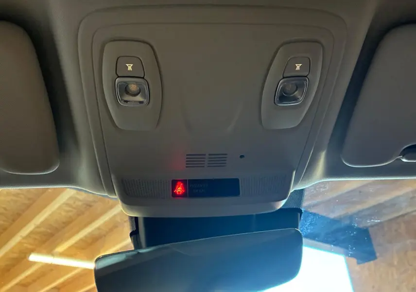 Vue intérieure du plafonnier gris clair de la Renault Mégane 1.5 DCI 115 Intens avec éclairages de lecture et témoin airbag passager.