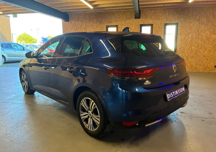 Vue 3/4 arrière droite d'une Renault Mégane 1.5 DCI 115 Intens bleu, avec feux arrière LED et jantes alliage biton.