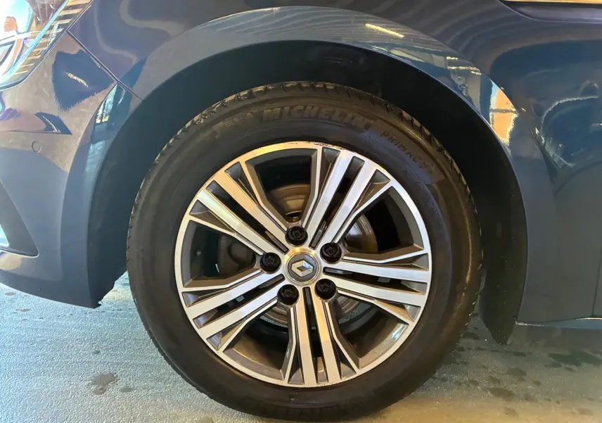 Gros plan sur la roue avant gauche d'une Renault Mégane bleu 2021 avec jante alliage et pneu Michelin.