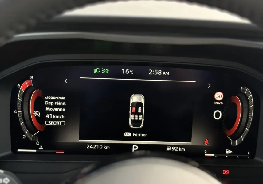 Combiné numérique du Nissan Qashqai 2025 affichant la vitesse moyenne, température et alertes, vue frontale du tableau de bord.