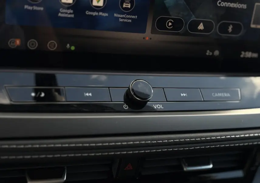 Gros plan sur la molette de volume et les commandes multimédia du tableau de bord du Nissan Qashqai gris argent 2025.