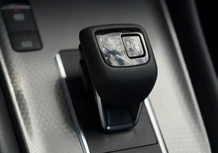 Le levier de vitesses automatique noir du Nissan Qashqai 2025 vu en gros plan sur console argentée.