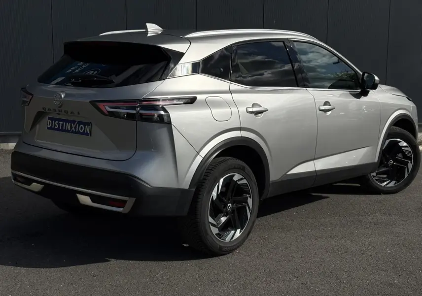 Nissan Qashqai gris argent vu en 3/4 arrière droit, avec hayon électrique et jantes alliage noires.