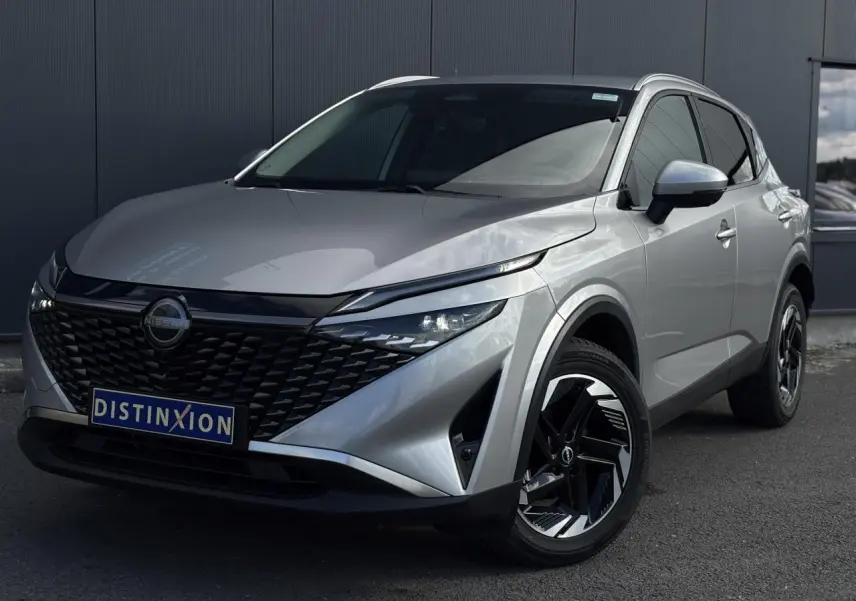 Nissan Qashqai gris argent vu en 3/4 avant droit avec calandre noire et jantes alliage 18 pouces.