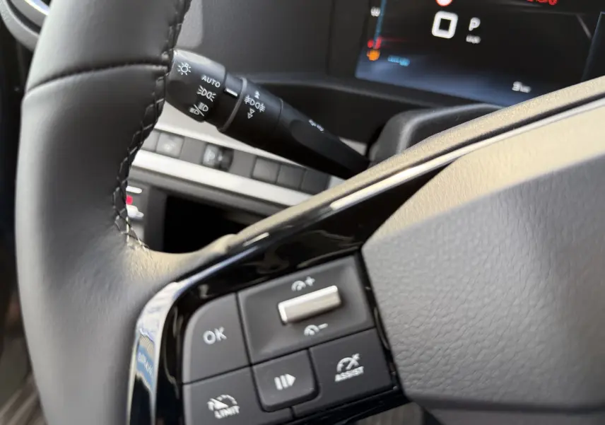 Gros plan sur les commandes au volant noir du Citroën Jumpy Cabine Approfondie 2026, affichage digital en arrière-plan.