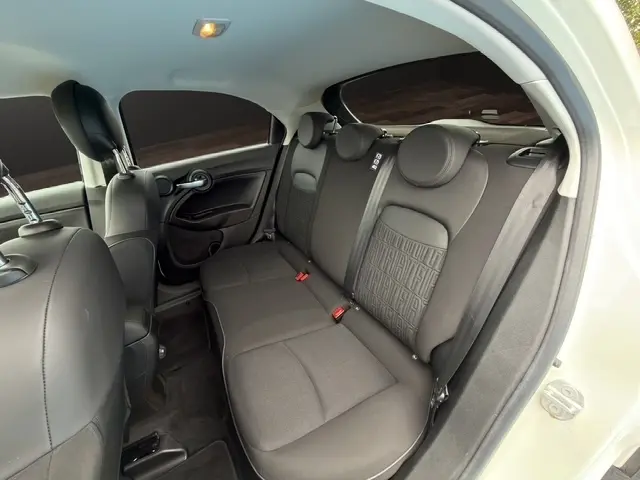 Vue intérieure arrière droite de la banquette noire du Fiat 500X 2023 avec ceintures et appuie-têtes intégrés.
