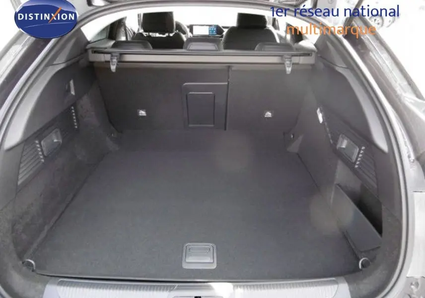 Coffre spacieux ouvert d'une Citroën C5 X gris platinium métal, vue arrière mettant en valeur l'intérieur noir et la tablette de séparation.