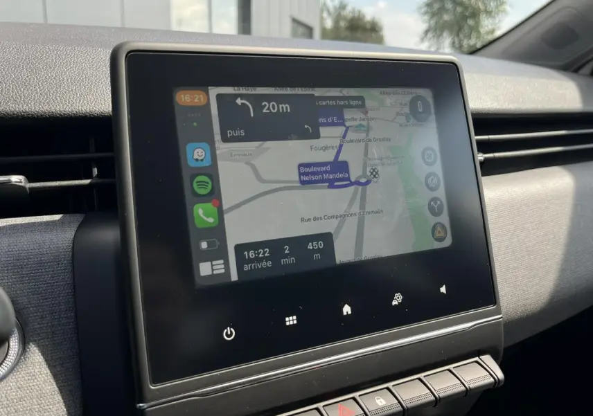 Écran tactile central de la Renault Clio 2025 affichant la navigation sur fond de tableau de bord gris.