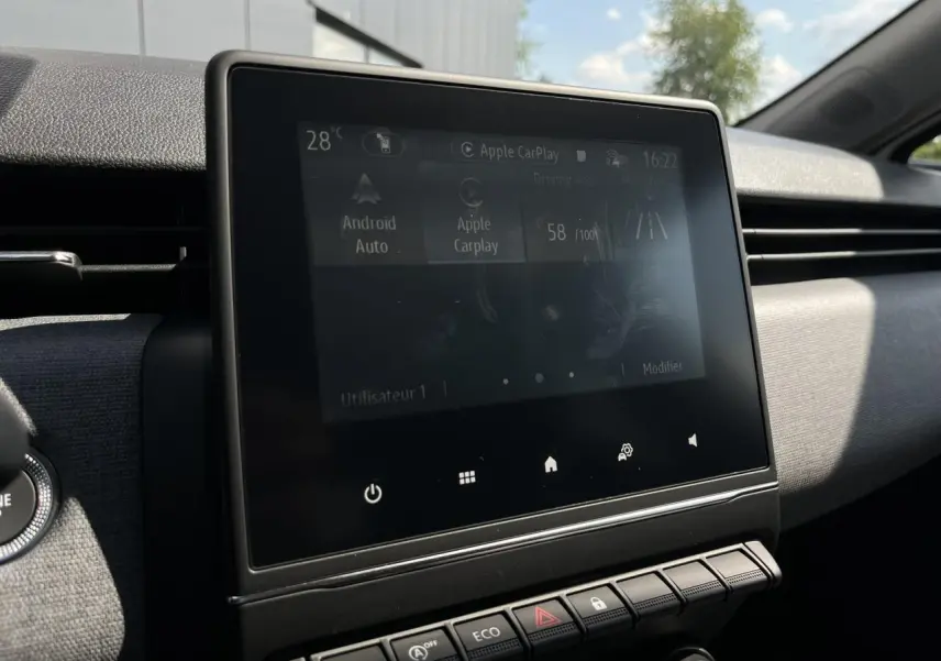 Écran tactile central de la Renault Clio 2025 affichant Android Auto et Apple CarPlay dans un intérieur sombre.