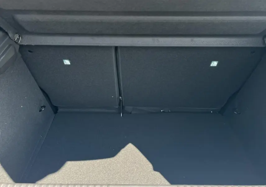 Coffre spacieux et vide de la Renault Clio 2025 blanc glacier, vue intérieure arrière avec banquette rabattue.